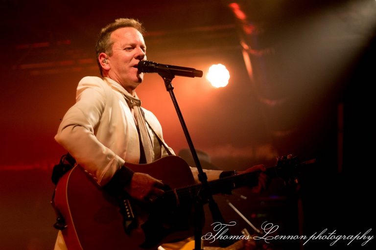 Kiefer Sutherland on stage playing a guitar