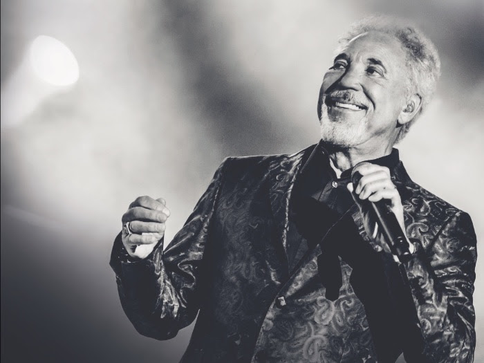 Tom Jones in black and white singing on stage