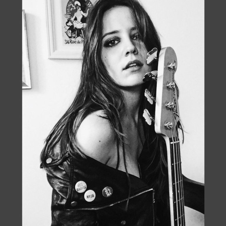 Lena Morris holding an electric guitar close