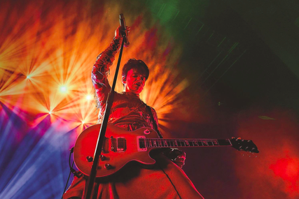 Gary numan on stage with a guitar