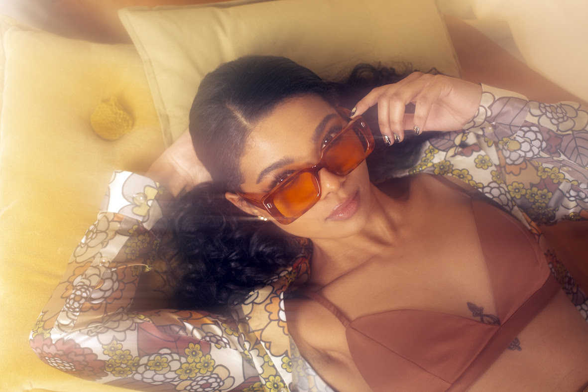 Brooke Combe in a bikini top and sunglasses