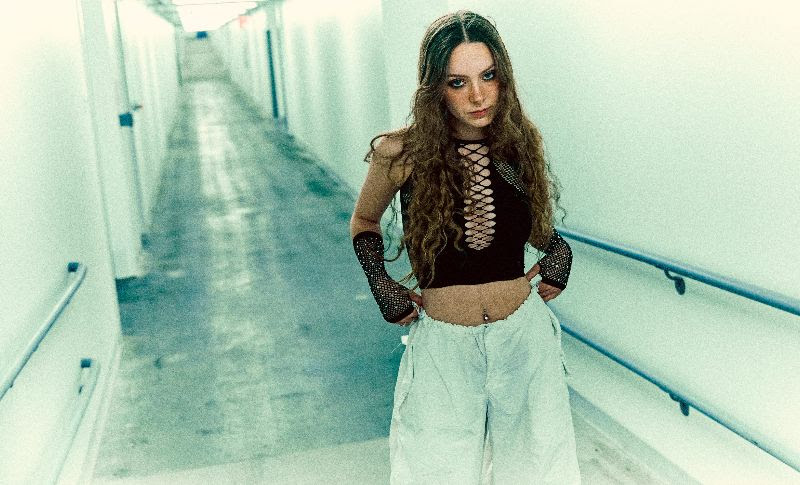 Holly Humberstone in a corridor wearing a laced top
