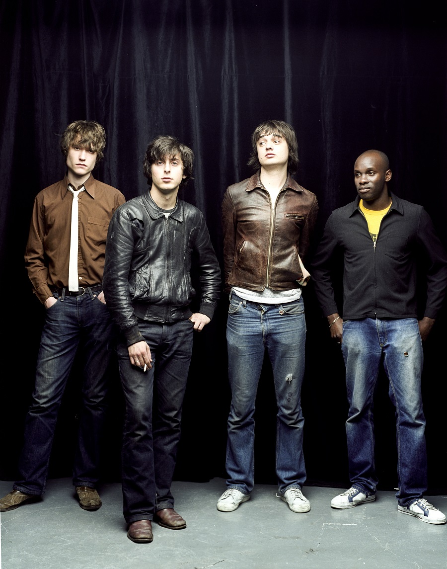 The Libertines stood in a line with a black curtain as a backdrop