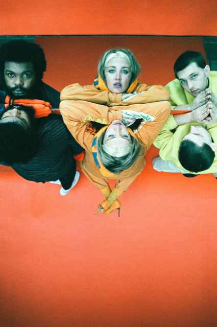 Dehd band members laying on a reflective orange surface