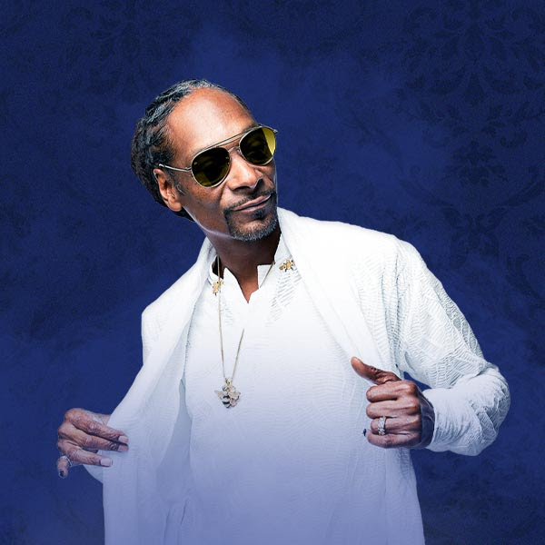 Snoop Dogg wearing a white top and shirt and sunglasses