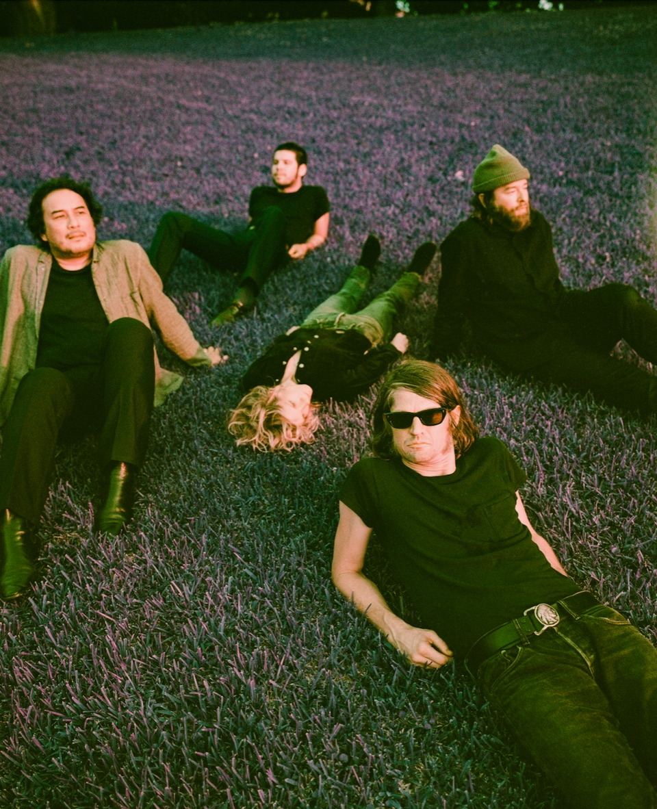 The black angels all sitting and lying in a field