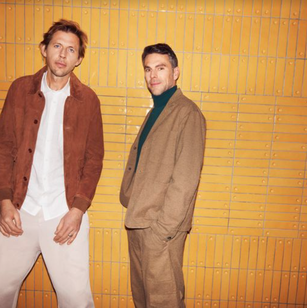 Groove Armada band members stood in front of a yellow wall