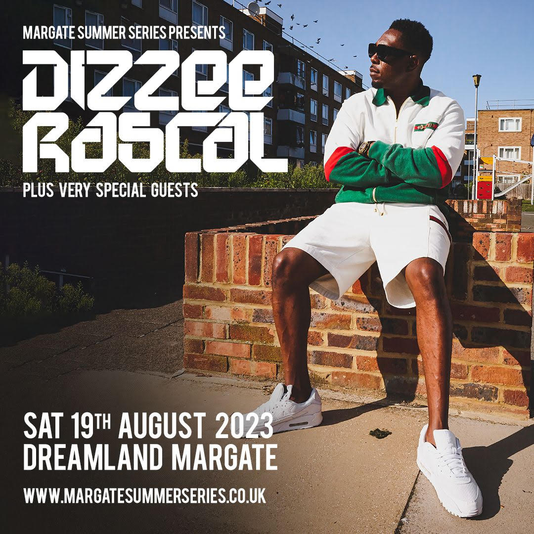 Dizzee Rascal sitting on a wall in a housing estate with a sports top, shorts and white trainers on