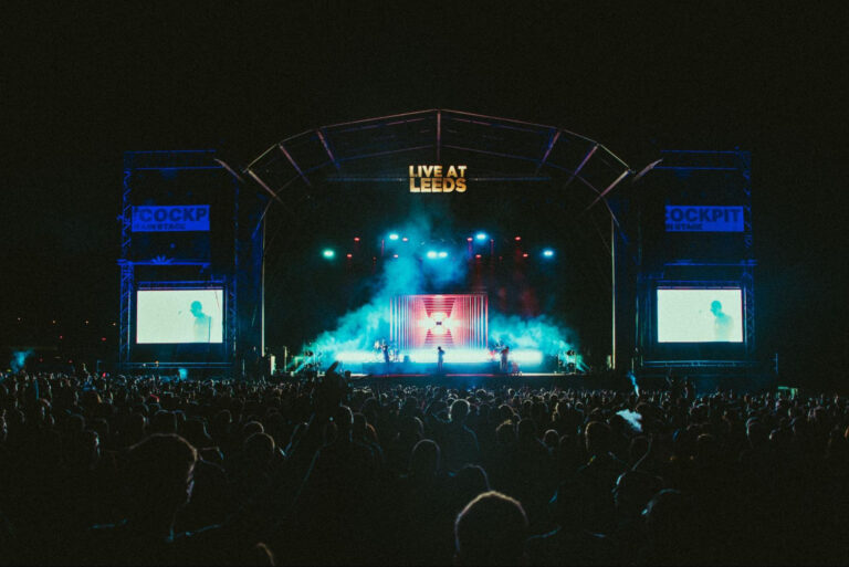 Stage with Live at leeds logo and crowd in front of it