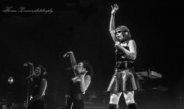 Paloma Faith on stage with her hand raised in the air