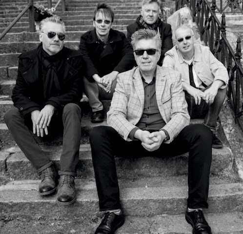 The undertones sitting on steps looking at the camera