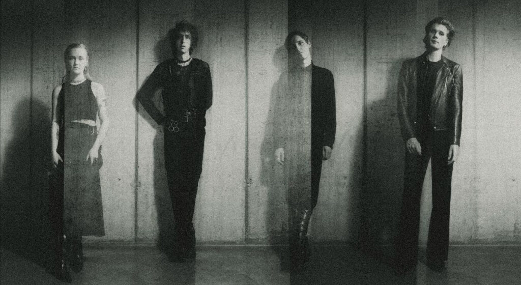 A faded ghostly black and white image of The horrors lined up against a wall 