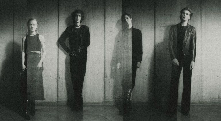 A faded ghostly black and white image of The horrors lined up against a wall