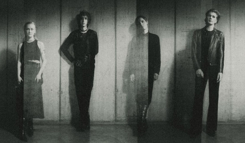 A faded ghostly black and white image of The horrors lined up against a wall