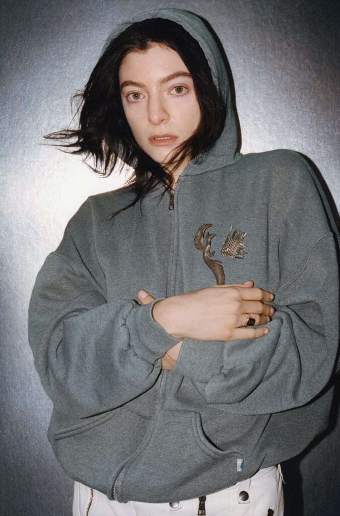 Lorde stood in a grey hoodie