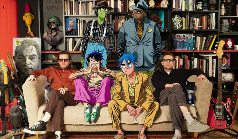 Gorillaz say on a sofa with Damon Albarn in a room full of books, art and guitars