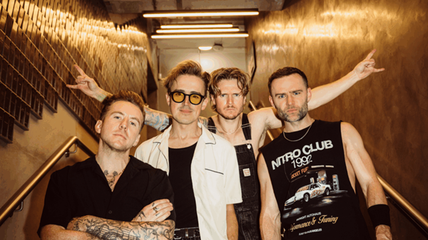 Mcfly stood at the bottom of some stairs looking at the camera