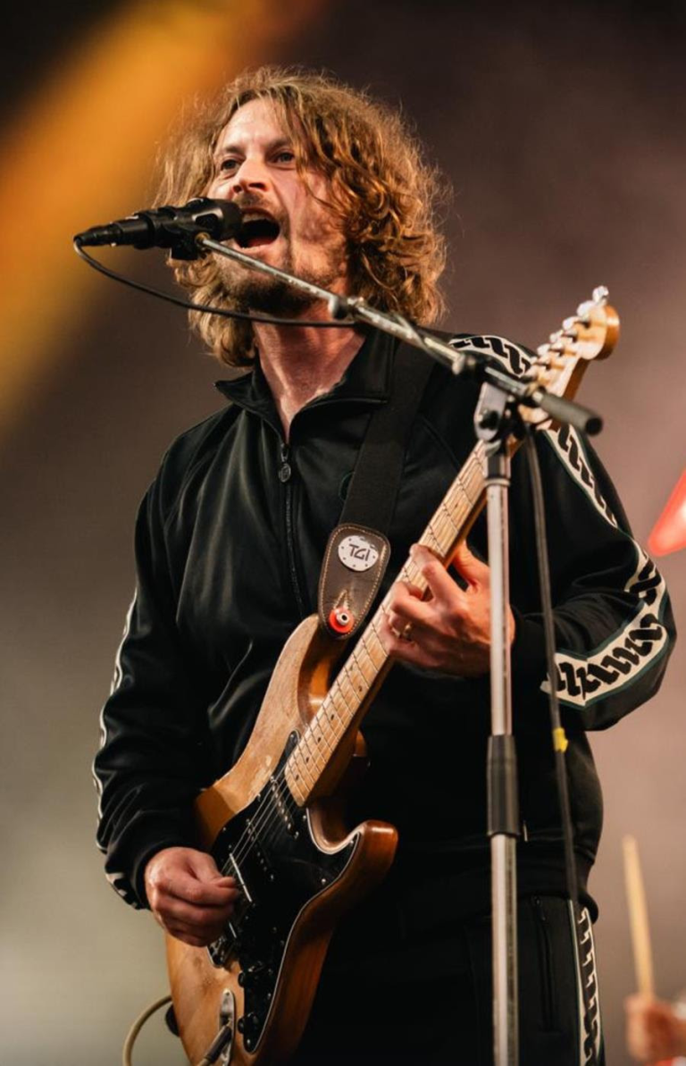 Dave McCabe singing on stage and playing his electric guitar