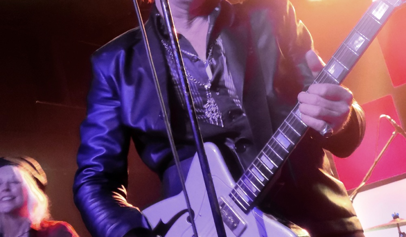 Jim Jones on stage playing his electric guitar