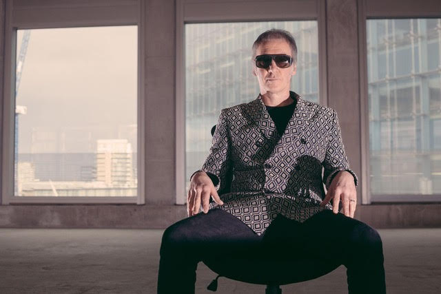 Clint Boon sitting in a chair in a room with sun glasses on